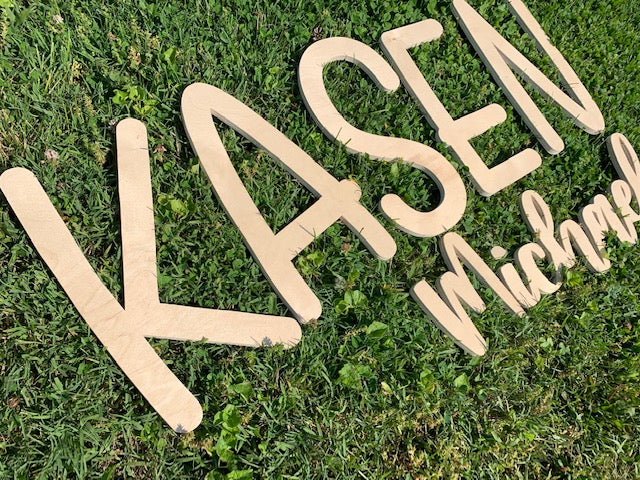 3D cut wording laying in the grass to show size